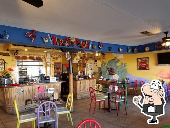 Inside El Ranchero — painted chiles, cactus mural, and colorful chairs